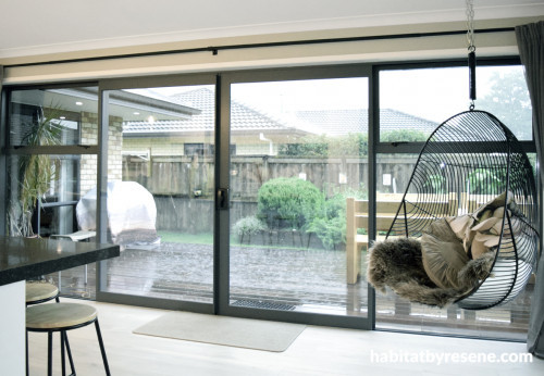 indoor outdoor flow, kitchen, living area, neutral dining room, deck, indoor hanging chair